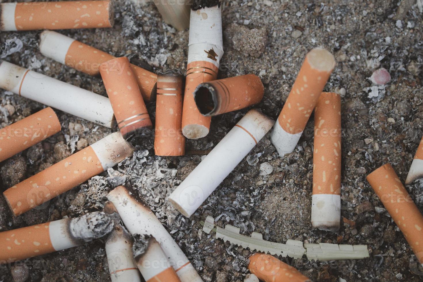 mozziconi di sigaretta combinati in un concetto di disco di sigaretta di molti detriti di sigaretta dopo aver fumato foto