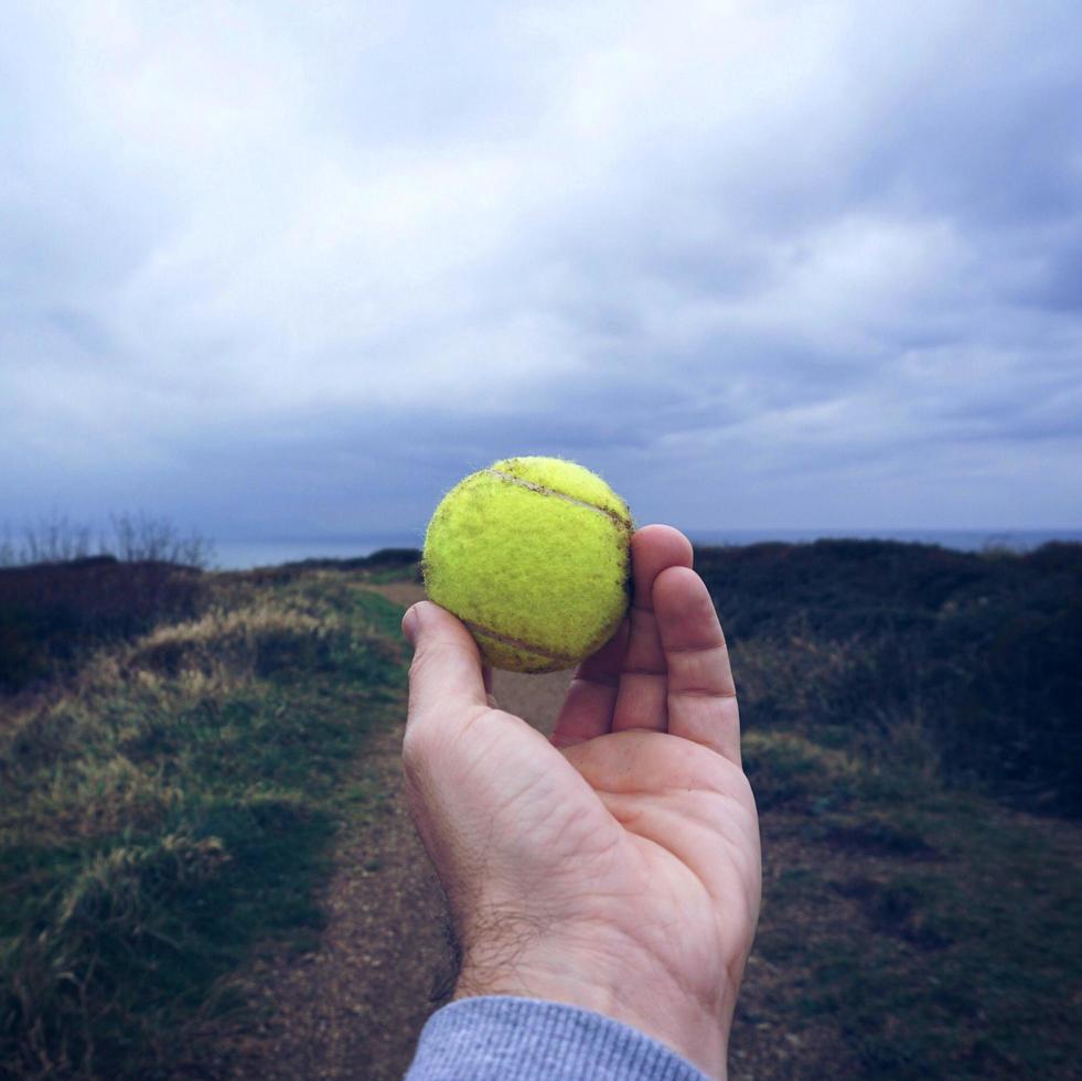 mano con una pallina da tennis foto