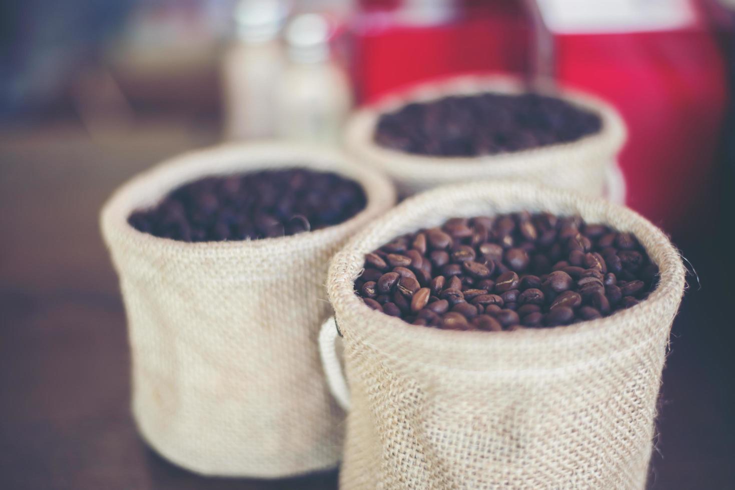 sacco di chicchi di caffè su fondo in legno foto