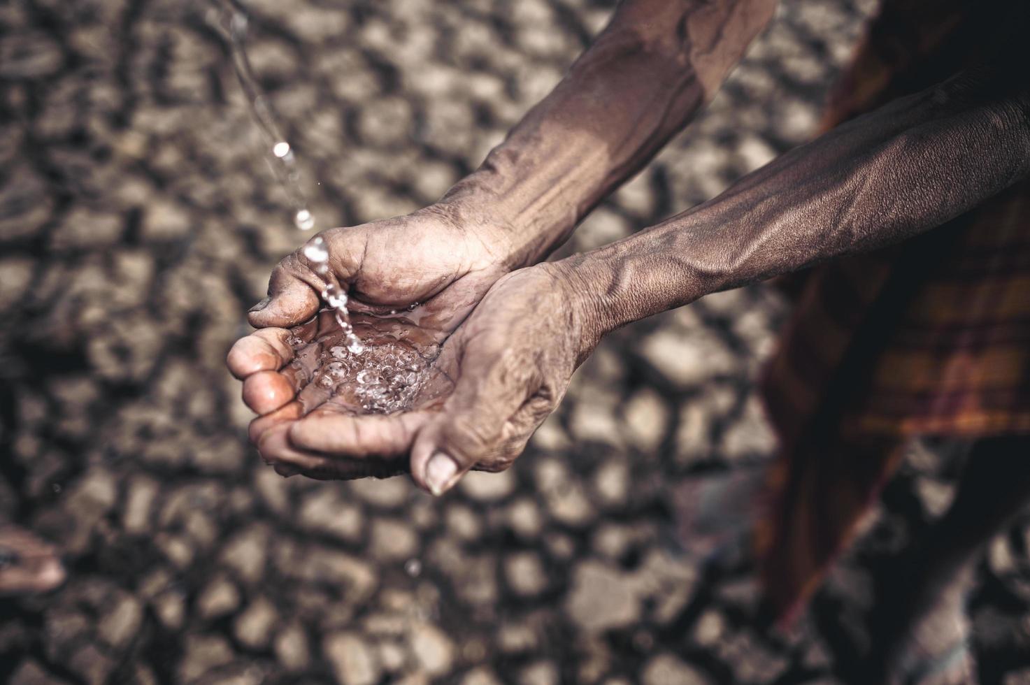 uomo anziano esposto all'acqua piovana con tempo asciutto foto