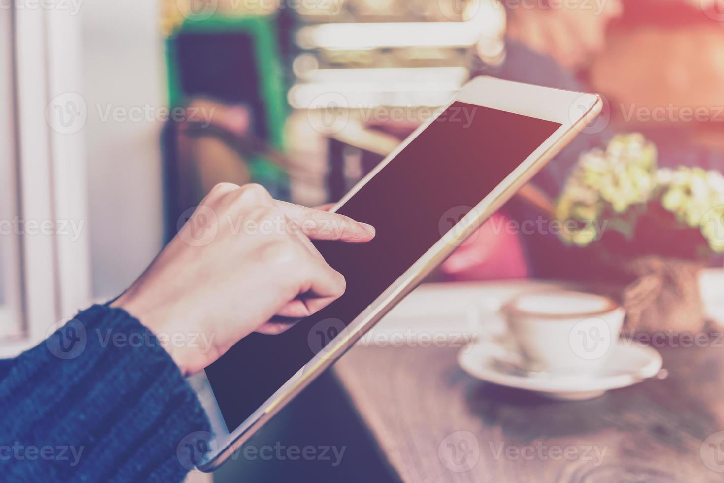 asiatico donna utilizzando tavoletta computer nel caffè negozio con Vintage ▾ tono. foto