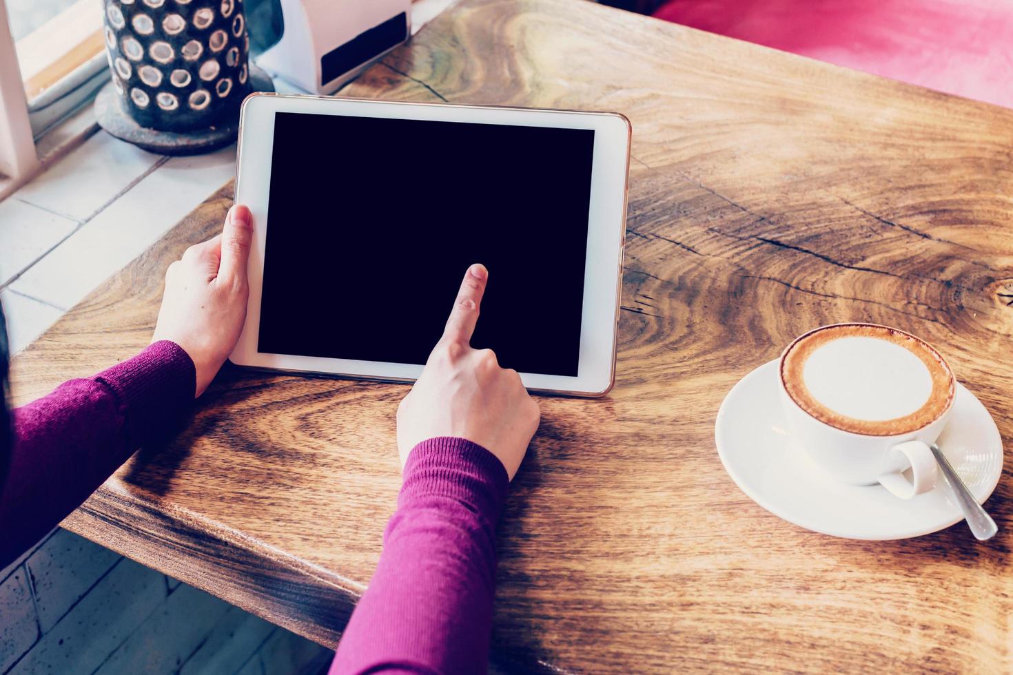 donna utilizzando tavoletta computer nel caffè negozio con Vintage ▾ tono. foto