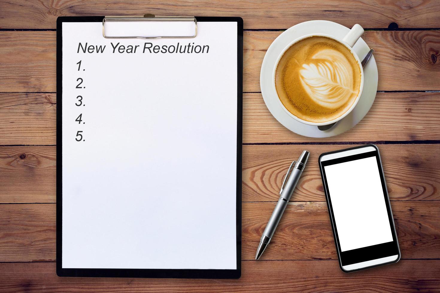 attività commerciale concetto - superiore Visualizza appunti scrittura nuovo anno risoluzione, penna, caffè tazza, e Telefono su legna tavolo. foto