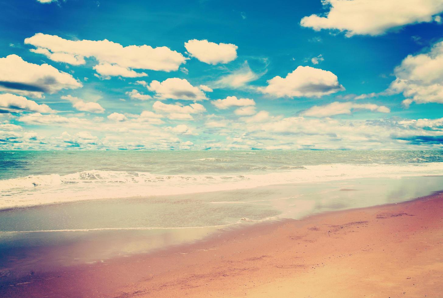 sabbia spiaggia mare e blu cielo nuvole con Vintage ▾ tono. foto