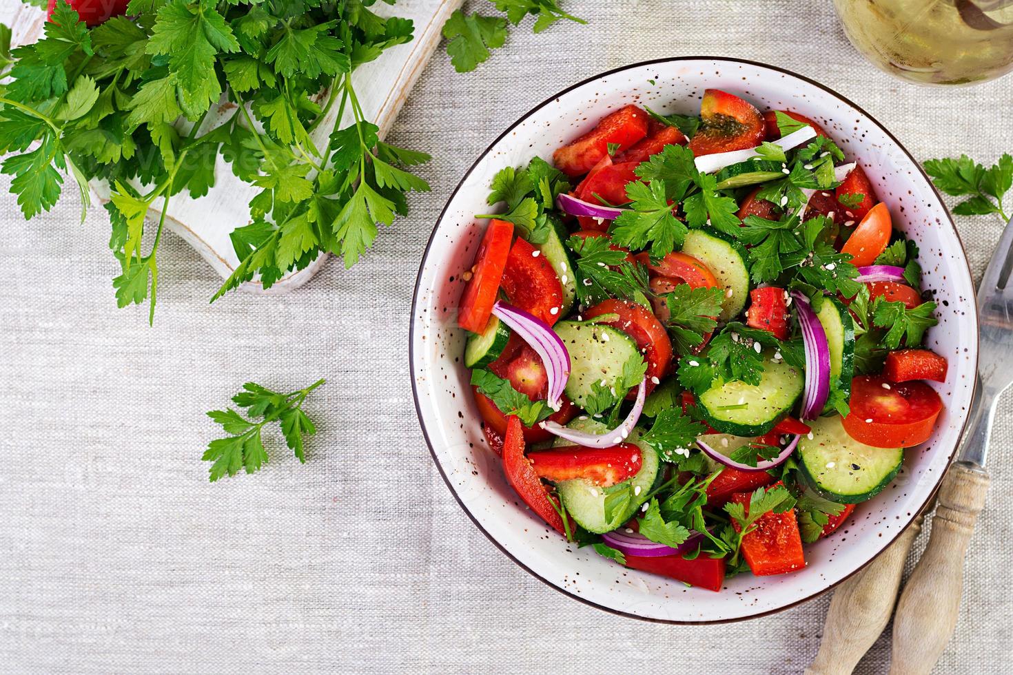 pomodoro e cetriolo insalata con rosso cipolla, paprica, nero Pepe e prezzemolo. vegano cibo. dieta menù. superiore Visualizza. piatto posare foto