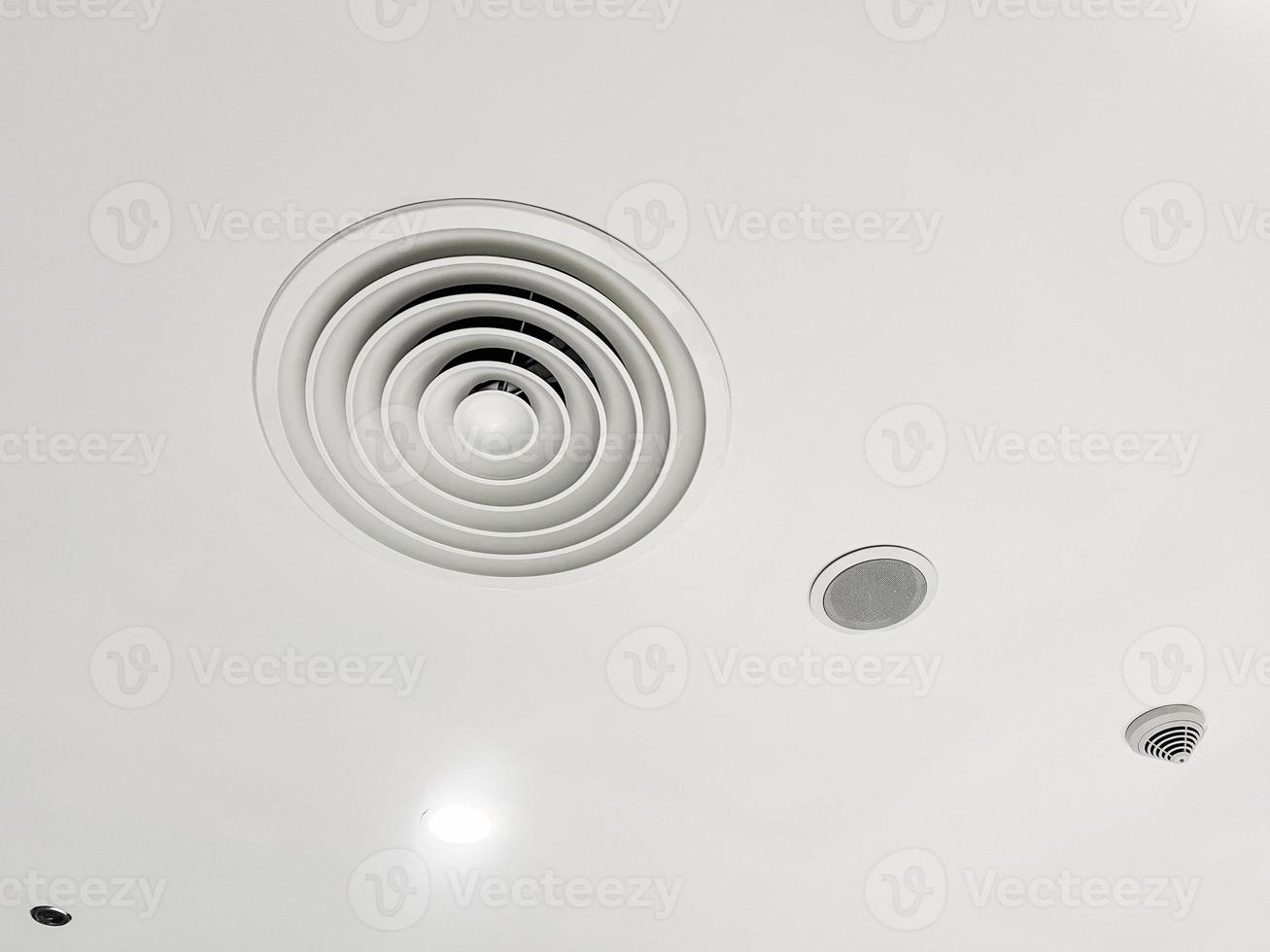 soffitto montato cassetta genere aria condizionatore e moderno lampada leggero su bianca soffitto. condotto aria condizionatore per casa o ufficio foto