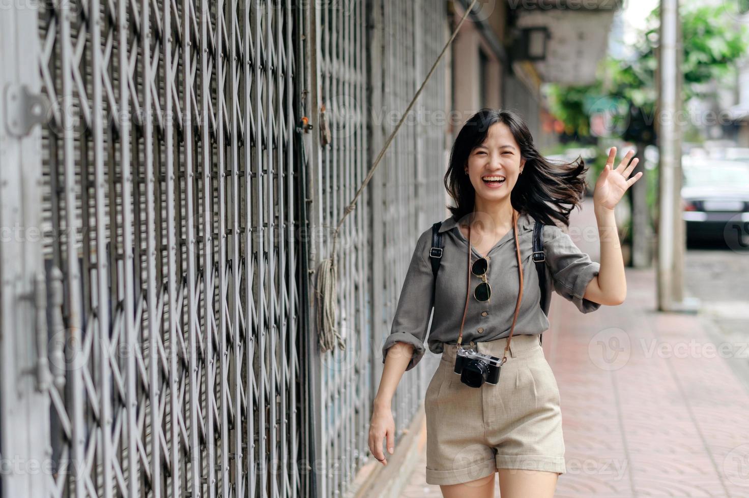 giovane asiatico donna zaino viaggiatore godendo strada culturale Locale posto e Sorridi. viaggiatore controllo su lato strade. foto