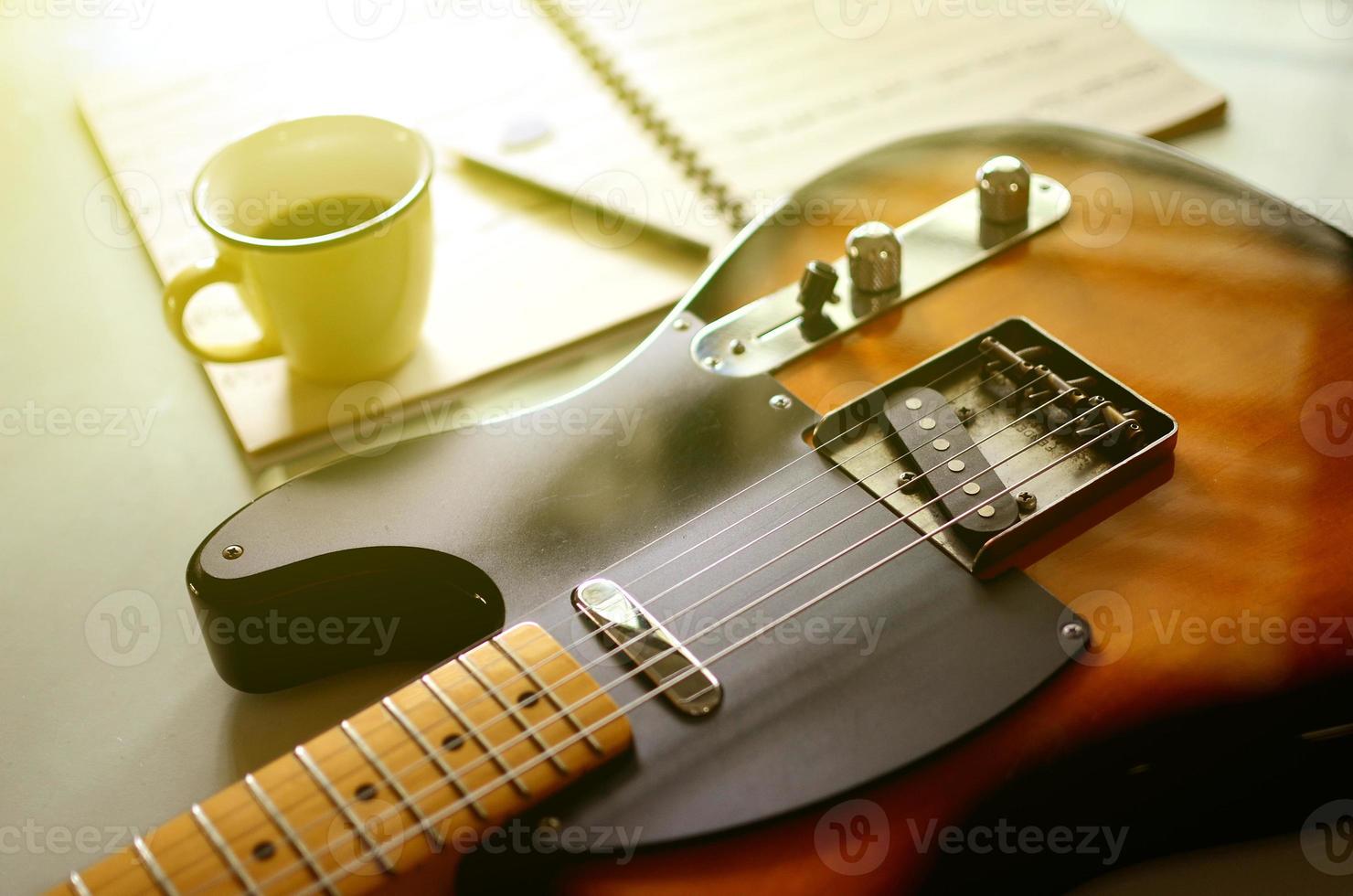 elettrico chitarra e un' tazza di caffè su legna sfondo foto