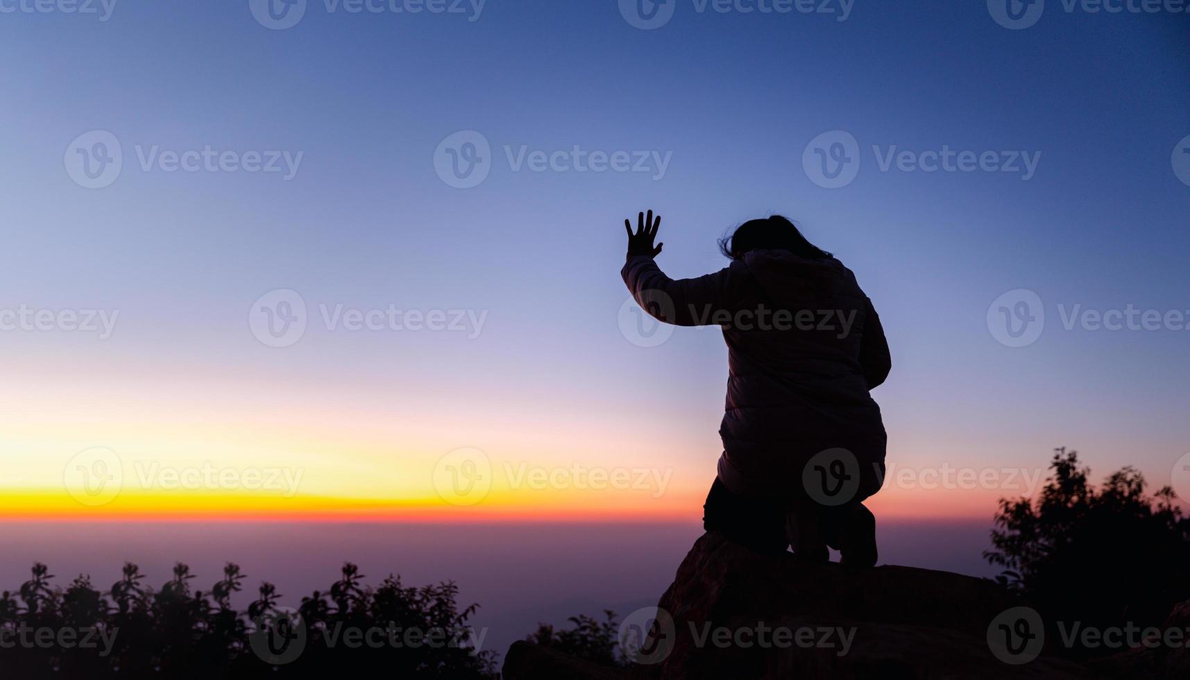 silhouette di donna in ginocchio giù preghiere per culto Dio a cielo sfondo. cristiani pregare per Gesù Cristo per calma. nel mattina persone avuto per un' silenzioso posto e pregato. bandiera con copia spazio. foto