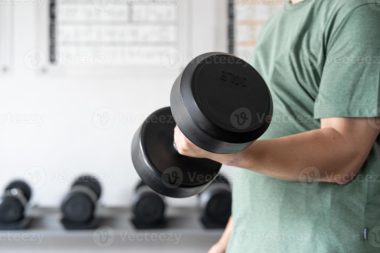 uomo allenarsi nel il interno palestra, uomo sollevamento su un' martello arricciare peso esercizio. bodybuilding manubri nel palestra. formazione nel fitness palestra. foto