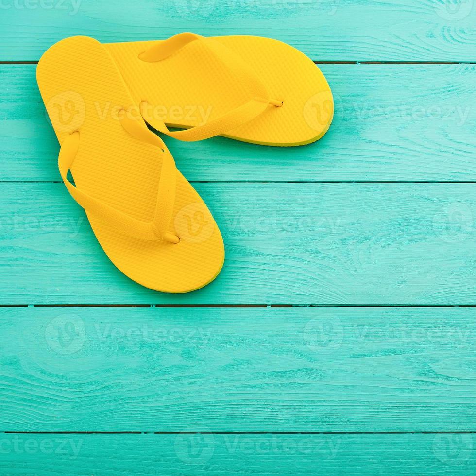 giallo Flip flop su blu di legno sfondo. estate vacanze. superiore Visualizza. finto su. copia spazio foto