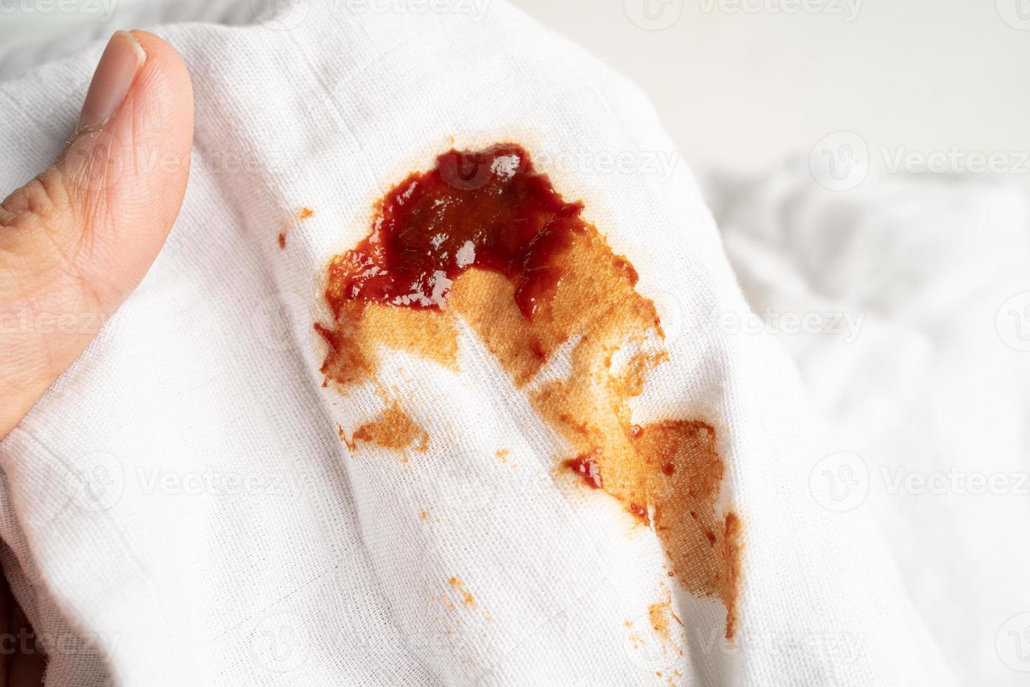 sporco pomodoro salsa macchia o ketchup su stoffa per lavare con lavaggio polvere, pulizia lavori di casa concetto. foto