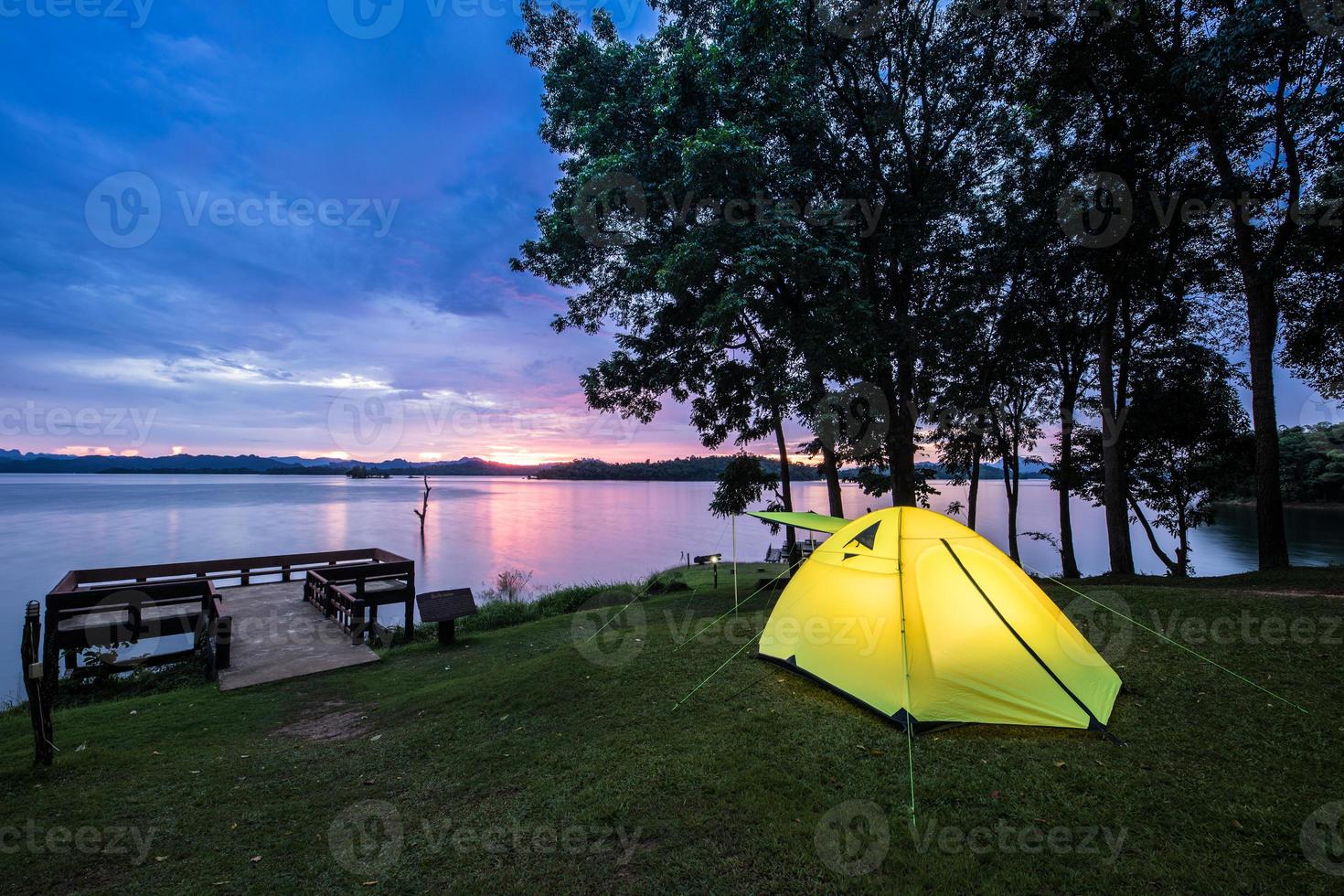 tenda vicino all'acqua al tramonto foto