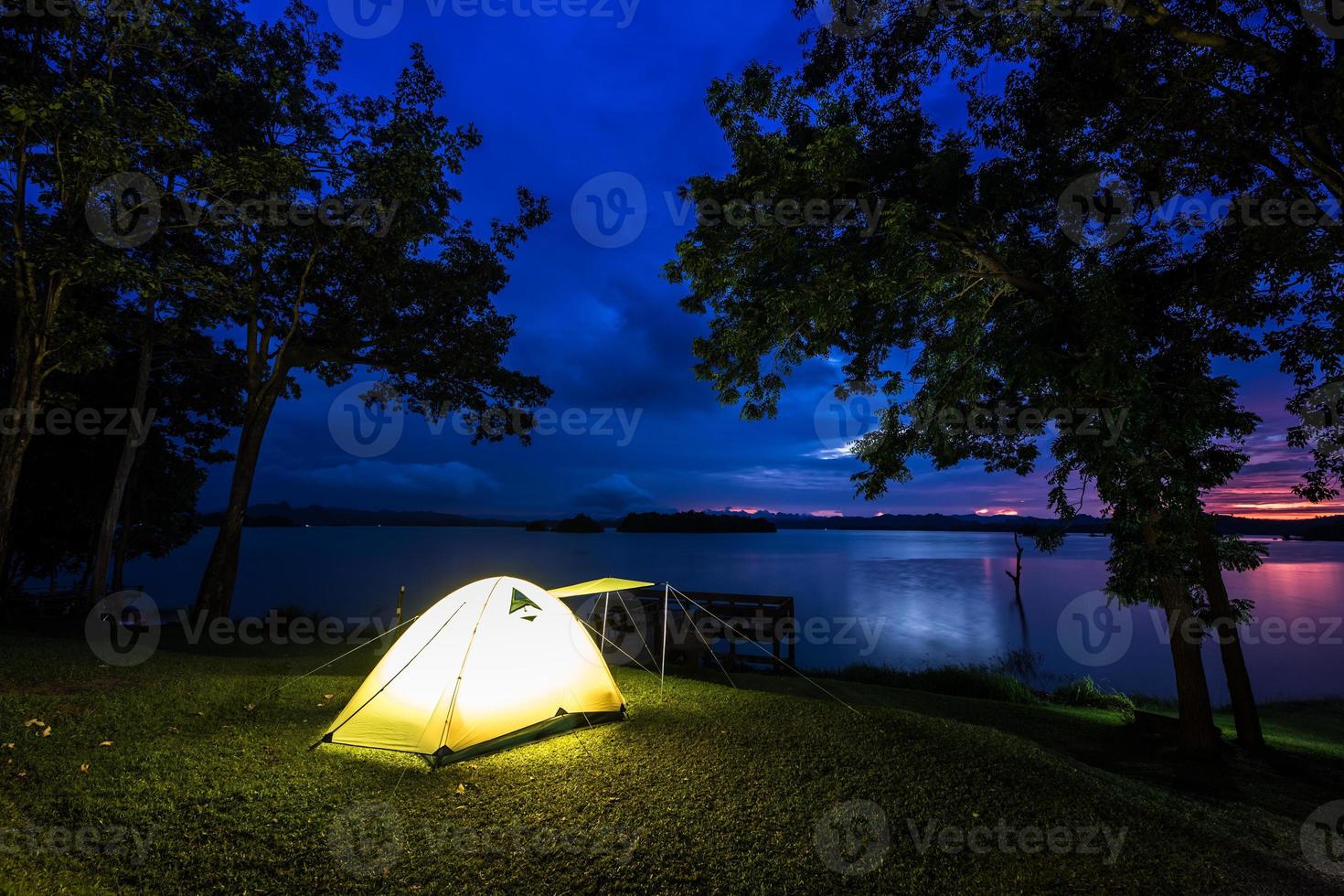 tenda vicino all'acqua al tramonto foto