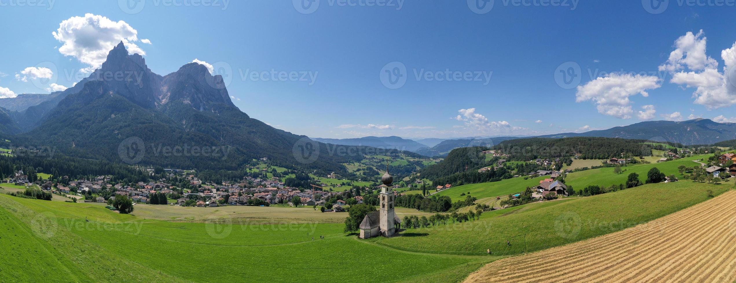 st. valentin castelrotto villaggio Chiesa nel il estate nel il dolomite Alpi. sorprendente paesaggio con piccolo cappella su soleggiato prato e petz picco a castelrotto comune. dolomiti, Sud tirolo, Italia foto