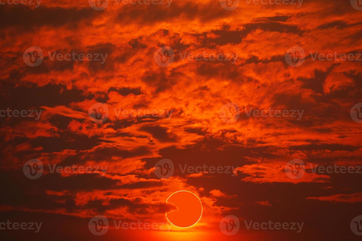 totale solare eclisse su rosso arancia cielo tramonto nel il sera foto