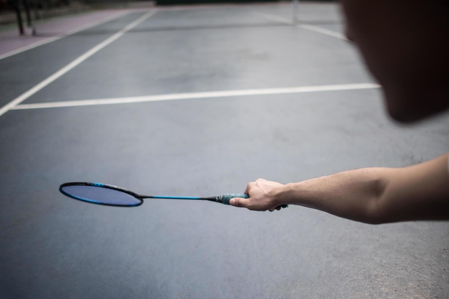 giovane che gioca a badminton all'aperto foto