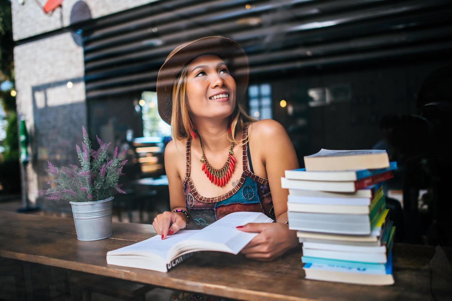 giovane donna che legge un libro in un caffè foto