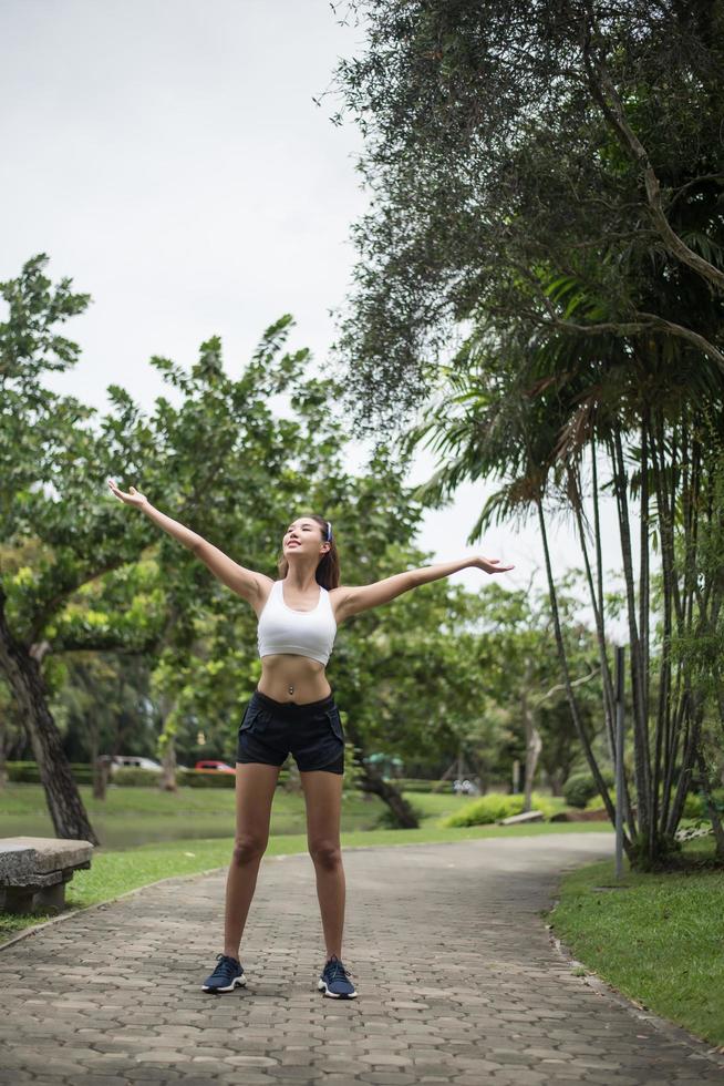 giovane donna sportiva che si estende nel parco foto