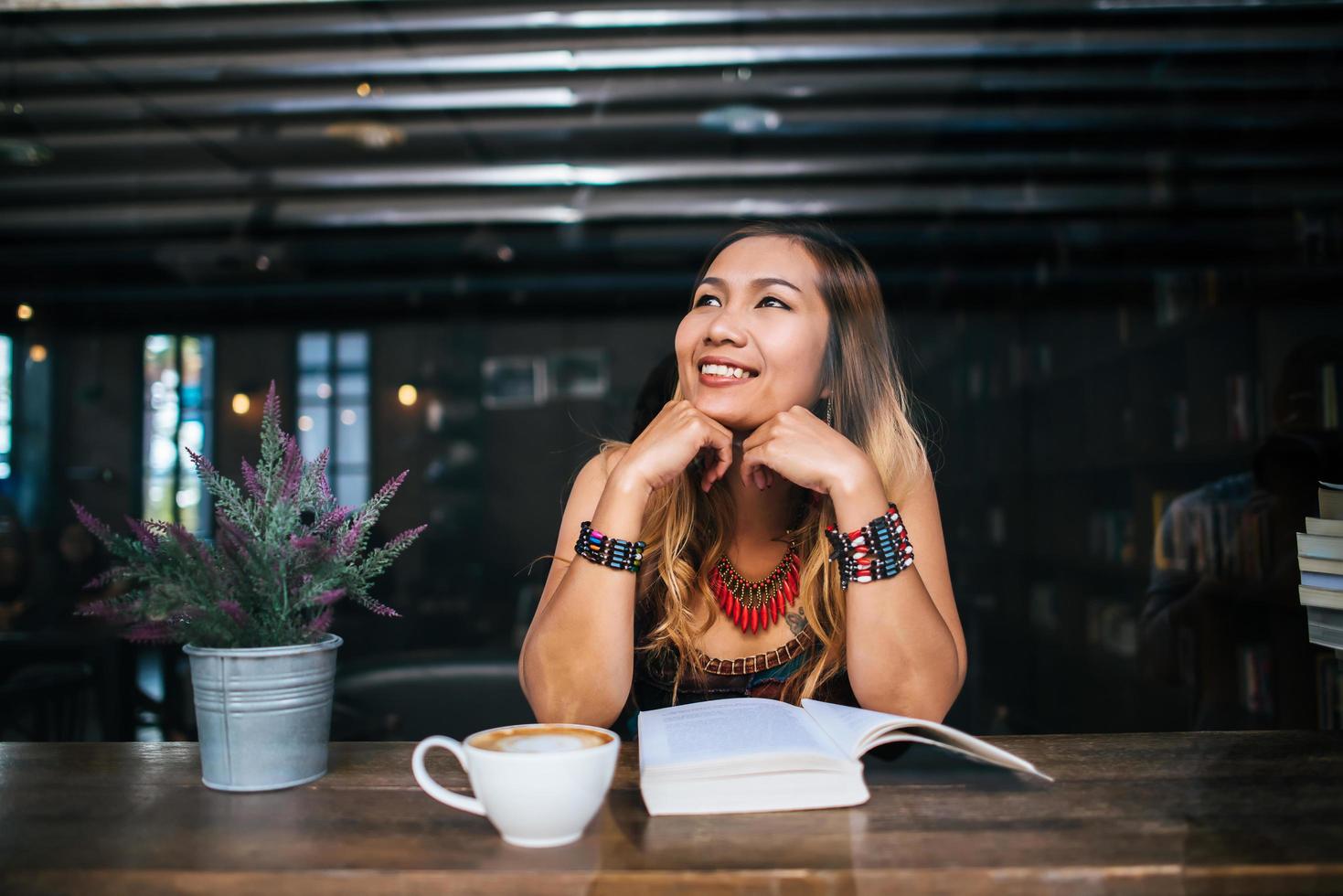 donna che beve cappuccino e legge un libro foto