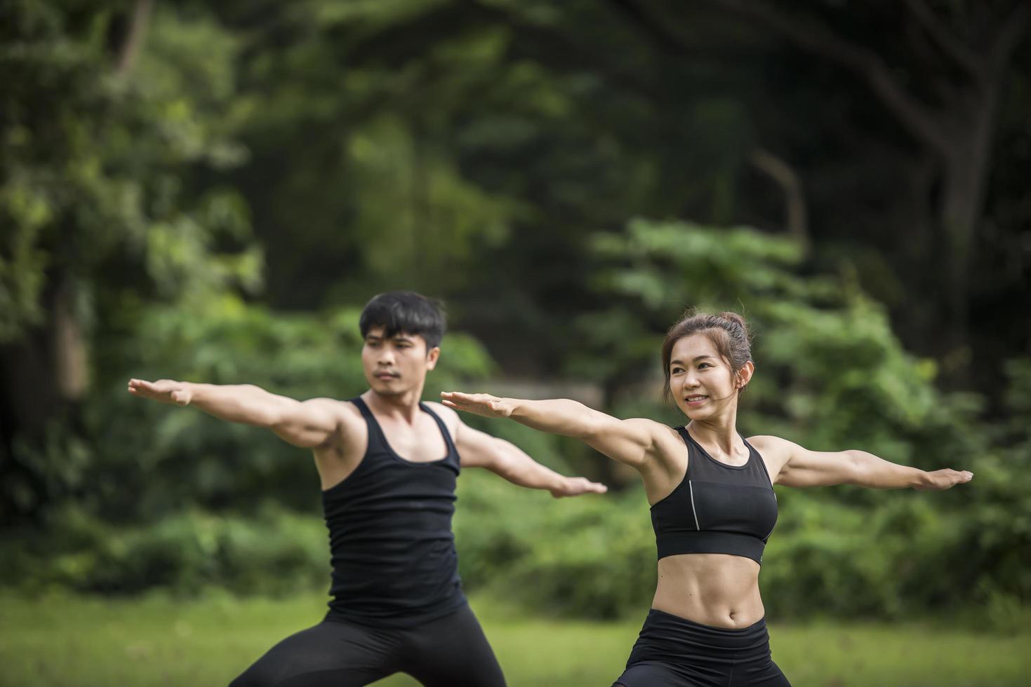 coppia che fa yoga nel parco foto