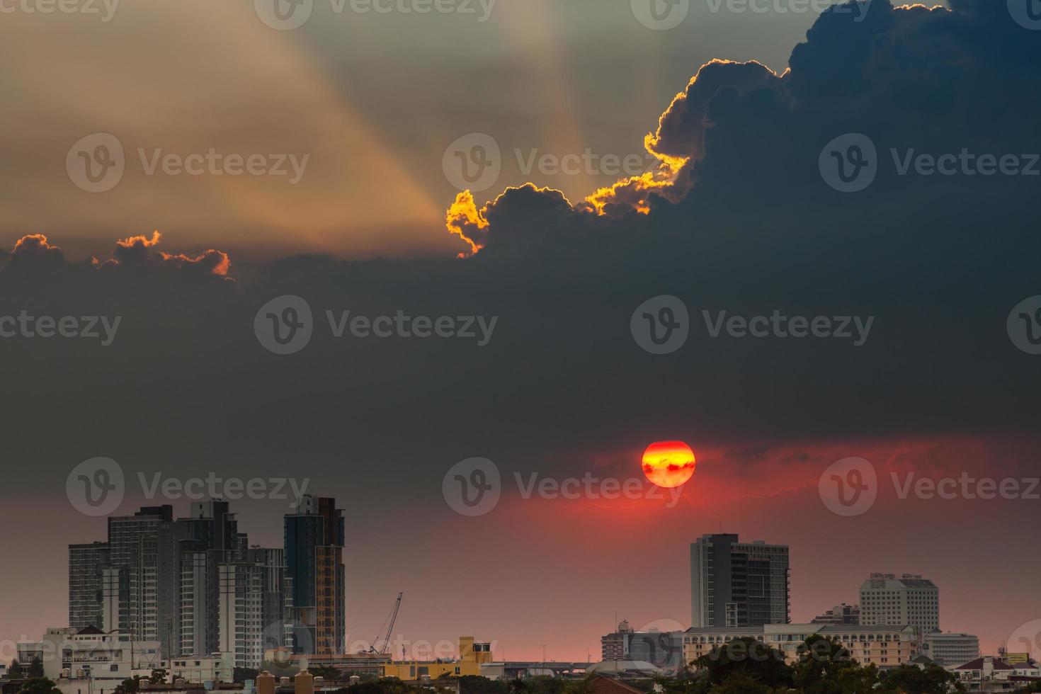 sole arancione e rosso e nuvole sopra la città foto