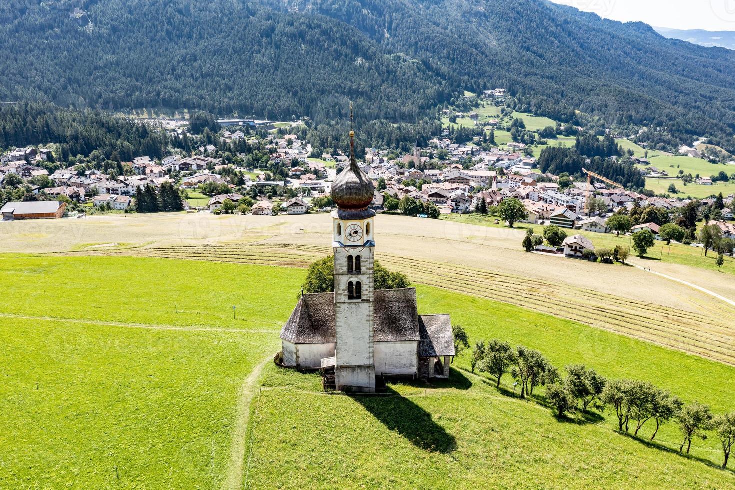 st. valentin castelrotto villaggio Chiesa nel il estate nel il dolomite Alpi. sorprendente paesaggio con piccolo cappella su soleggiato prato e petz picco a castelrotto comune. dolomiti, Sud tirolo, Italia foto