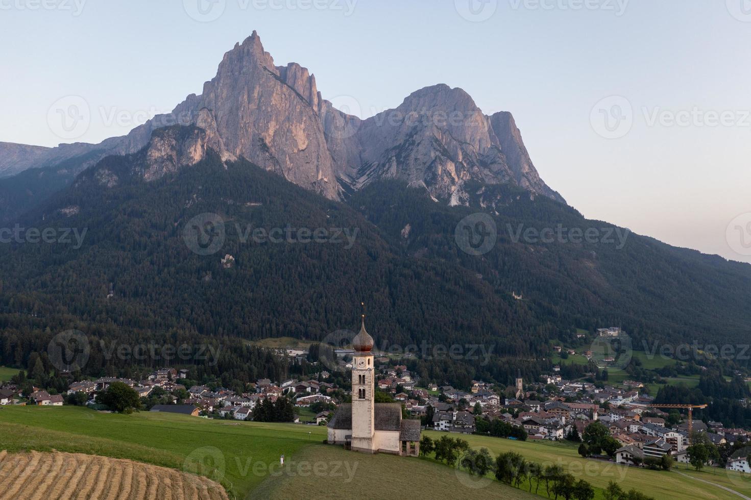 st. valentin castelrotto villaggio Chiesa nel il estate nel il dolomite Alpi. sorprendente paesaggio con piccolo cappella su soleggiato prato e petz picco a castelrotto comune. dolomiti, Sud tirolo, Italia foto