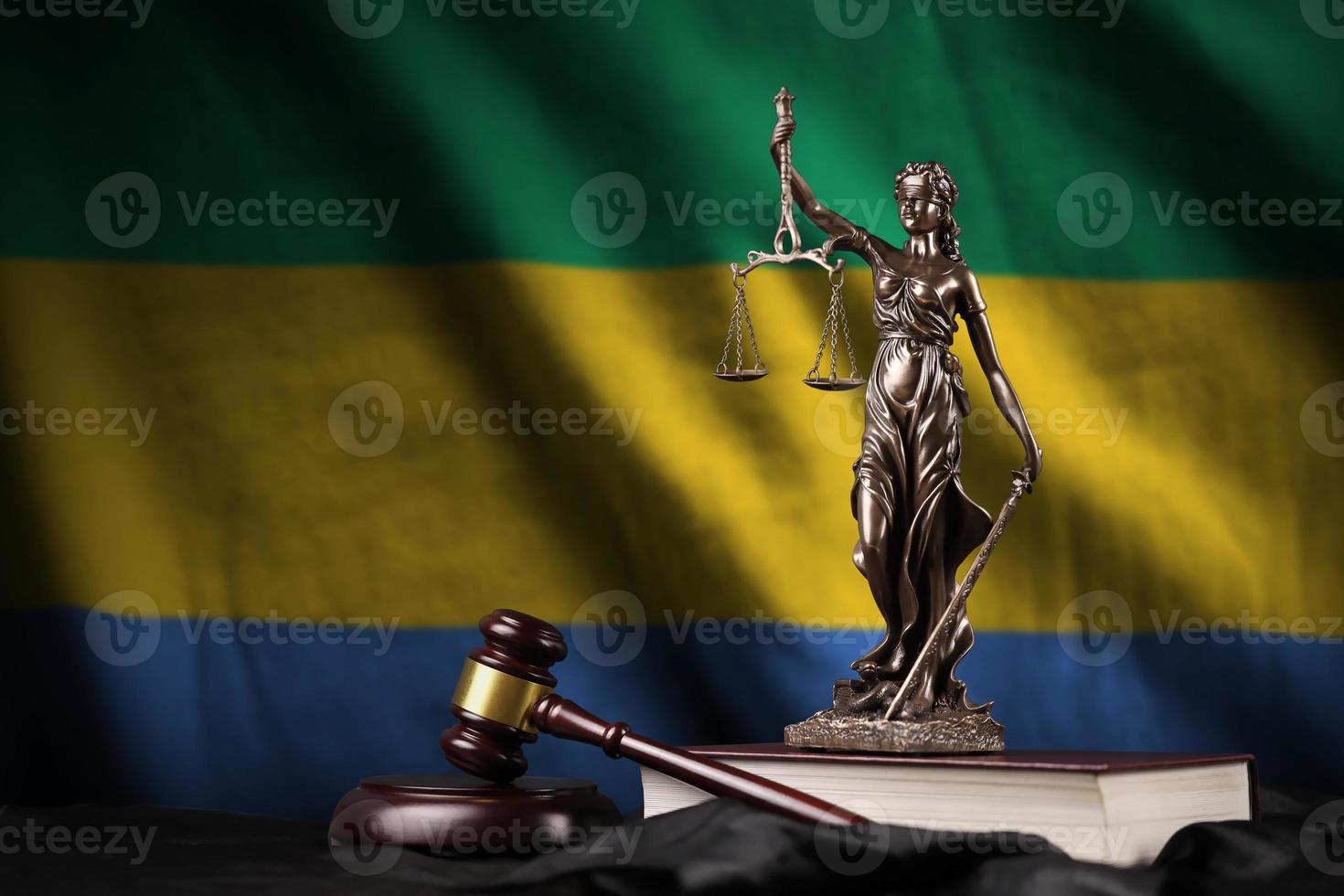 Gabon bandiera con statua di signora giustizia, costituzione e giudice martello su nero drappeggio. concetto di giudizio e colpa foto
