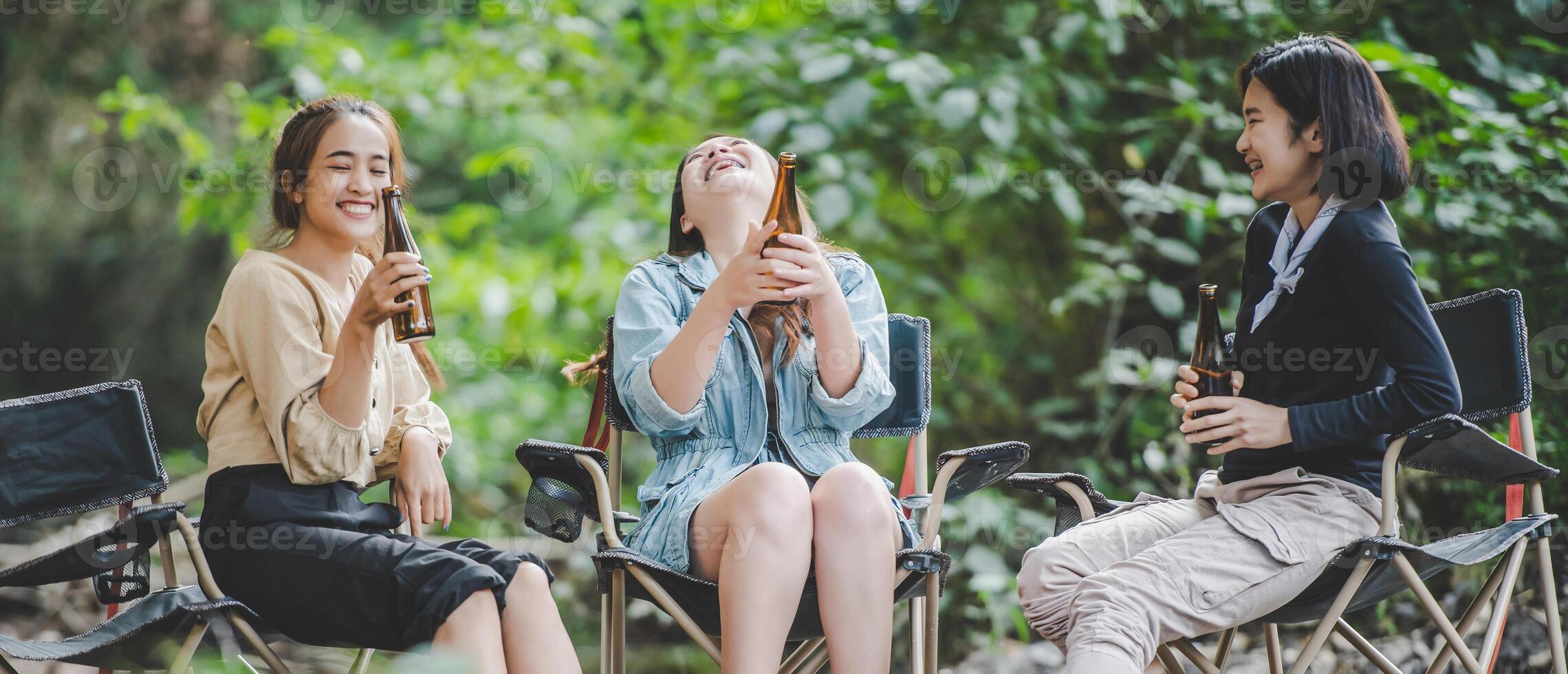 gruppo di donne bevanda birra e inzuppato piedi nel ruscello foto