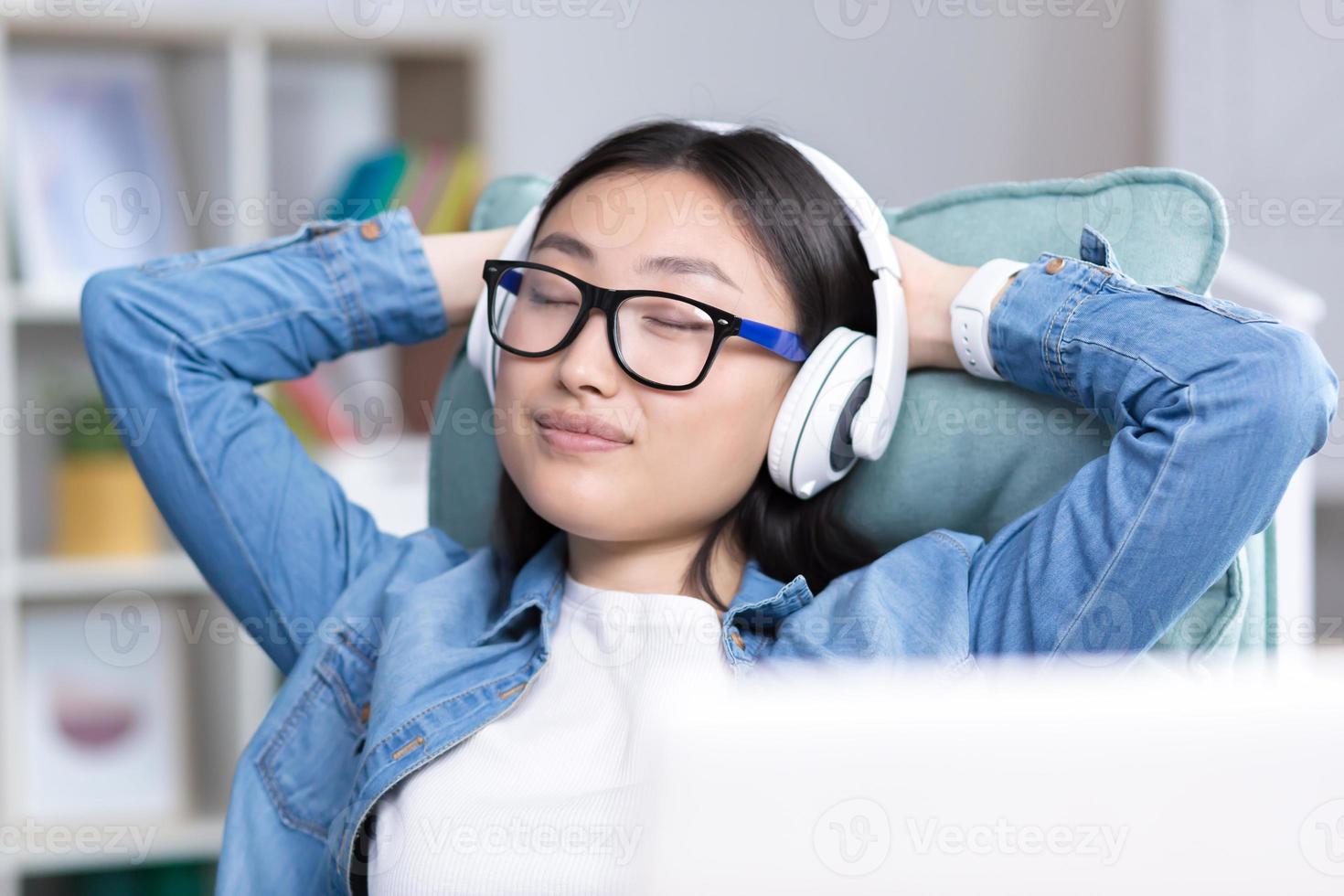 giovane bellissimo asiatico donna ascoltando per musica nel cuffie foto