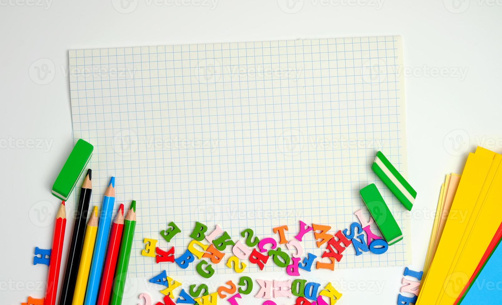 scuola forniture multicolore di legno matite, taccuino, colorato carta e vuoto bianca foglio nel un' check-box foto
