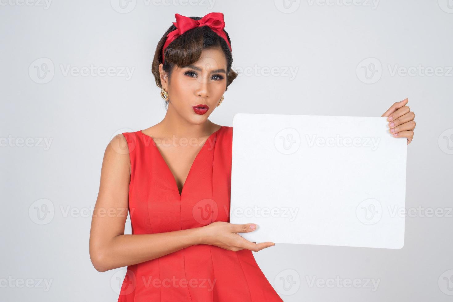 ritratto di una donna alla moda che mostra uno striscione bianco foto