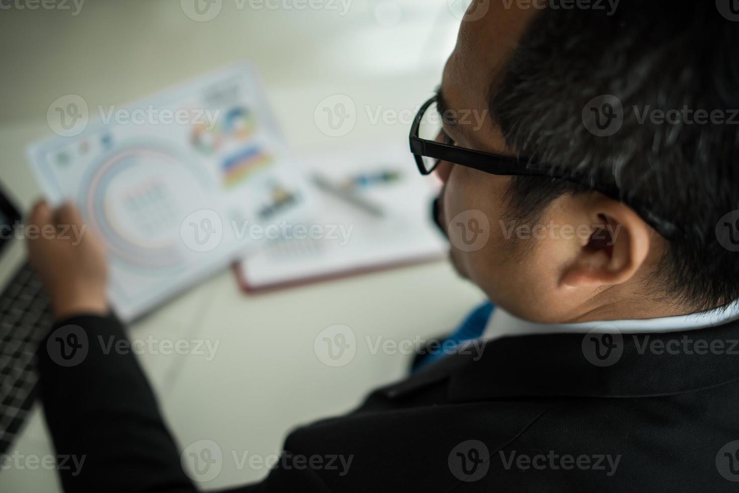 giovane uomo d'affari che lavora con il computer portatile in ufficio foto
