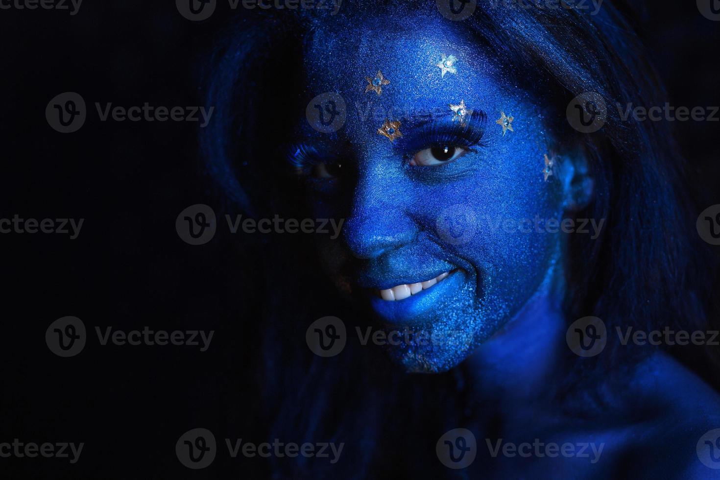 giovane simpatico ragazza con blu viso pittura foto