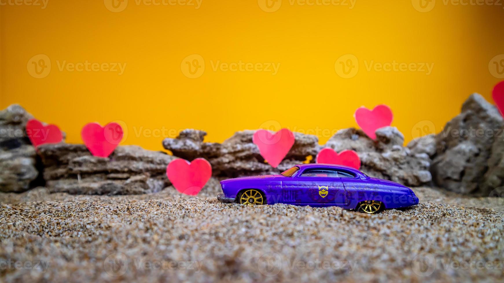 Minahasa, Indonesia dicembre 2022, giocattolo auto con pendenza arancia sfondo e un' cuore foto