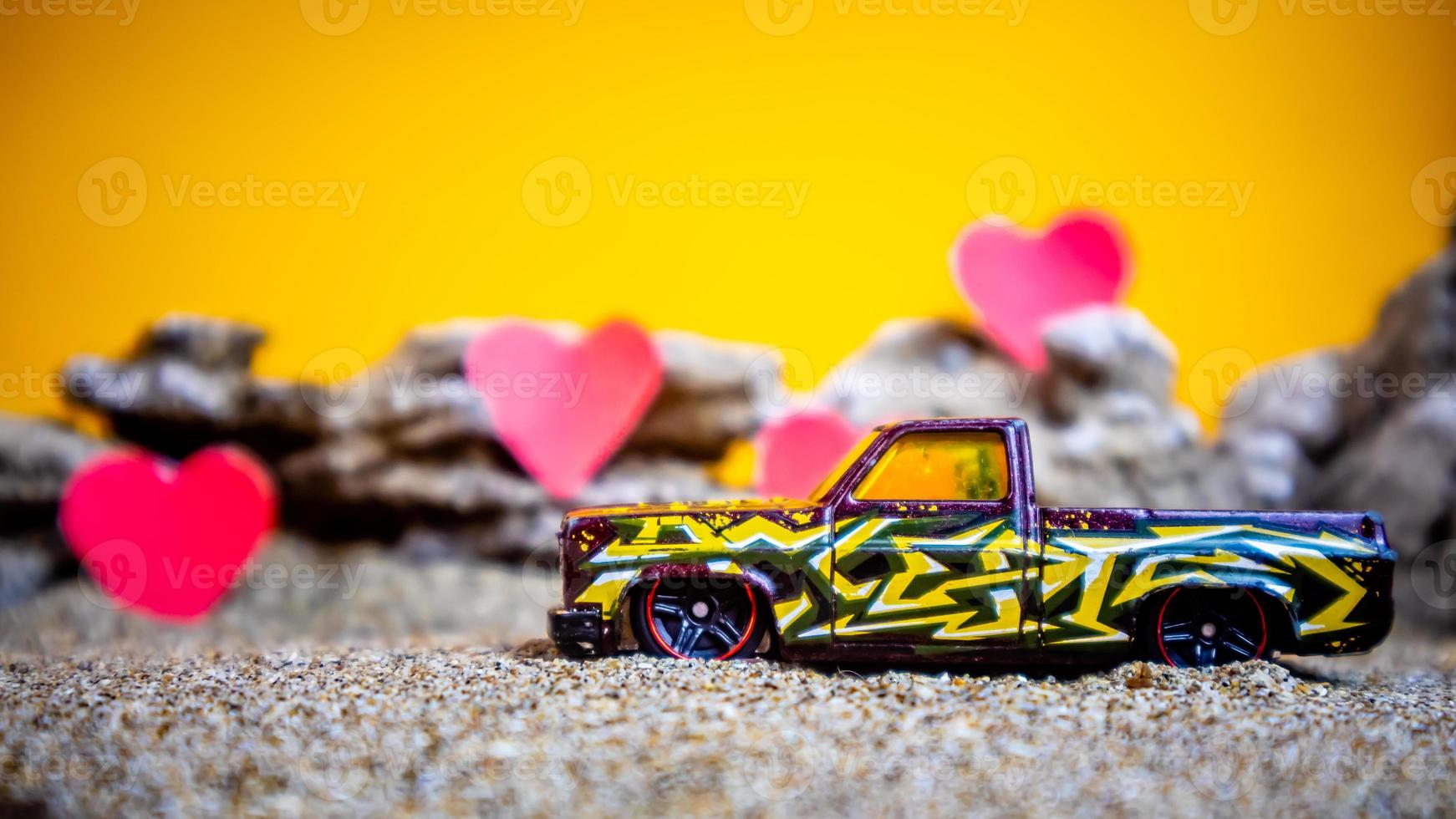 Minahasa, Indonesia dicembre 2022, giocattolo auto con pendenza arancia sfondo e un' cuore foto
