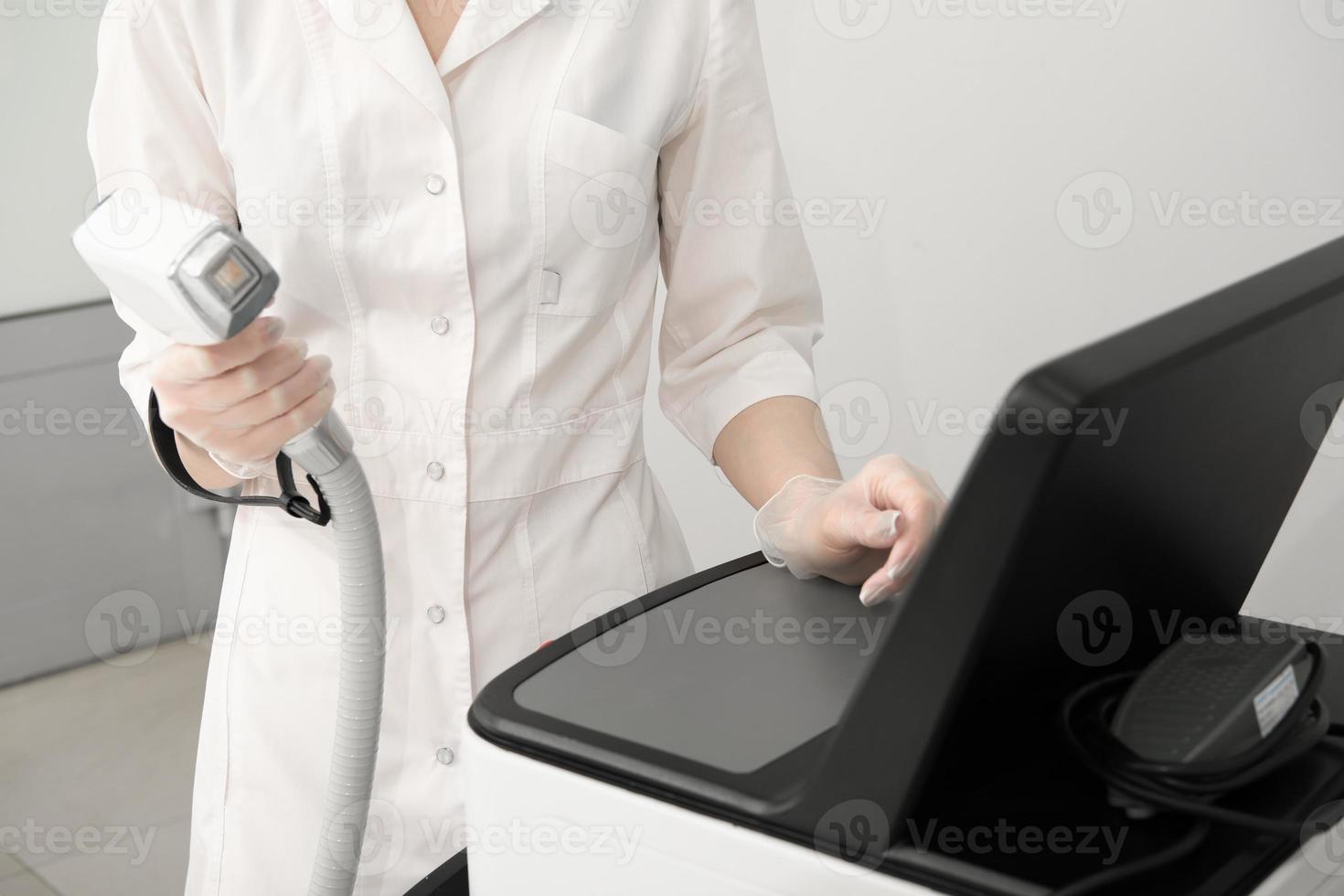 donna nel bianca uniforme regolazione laser depilazione macchina nel bellezza salone. corpo cura e cosmetologia concetto. foto
