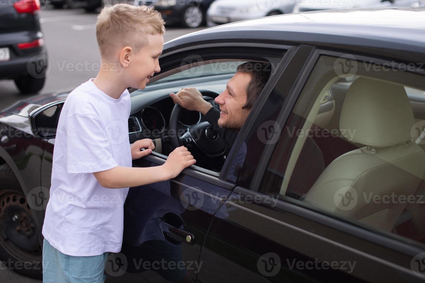 papà è venuto casa nel un' nero macchina. figlio incontra padre foto