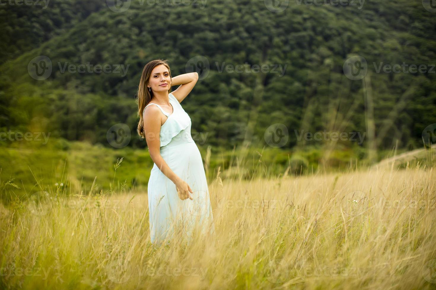 giovane donna incinta rilassante fuori nella natura foto