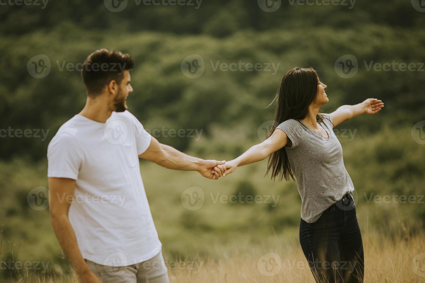 felice giovane coppia innamorata camminando attraverso l'erba foto