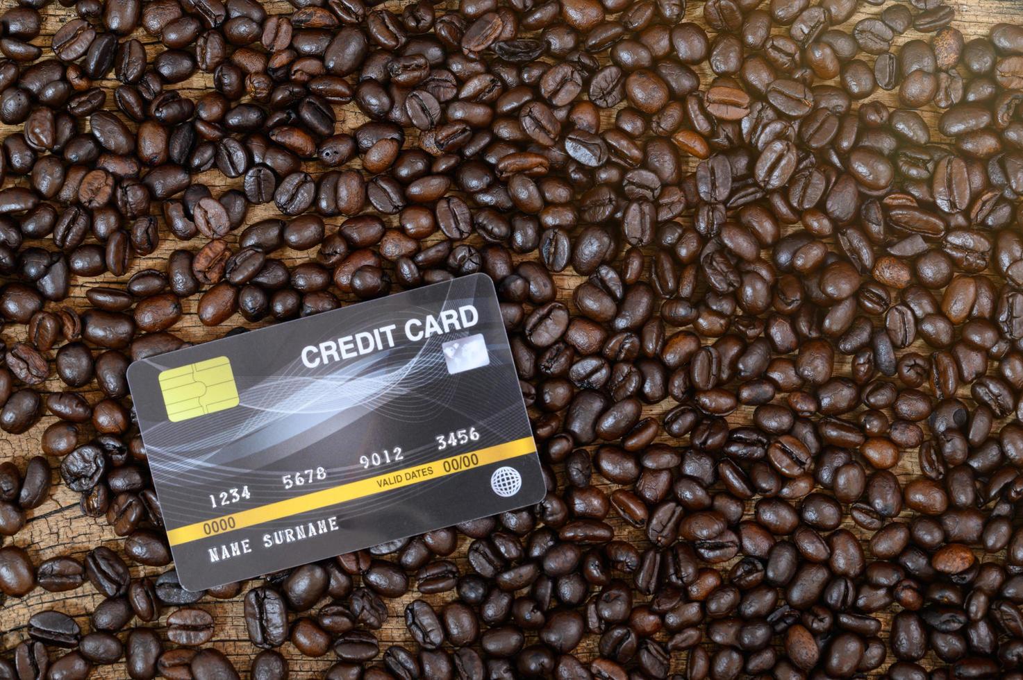 una carta di credito posta sui chicchi di caffè foto