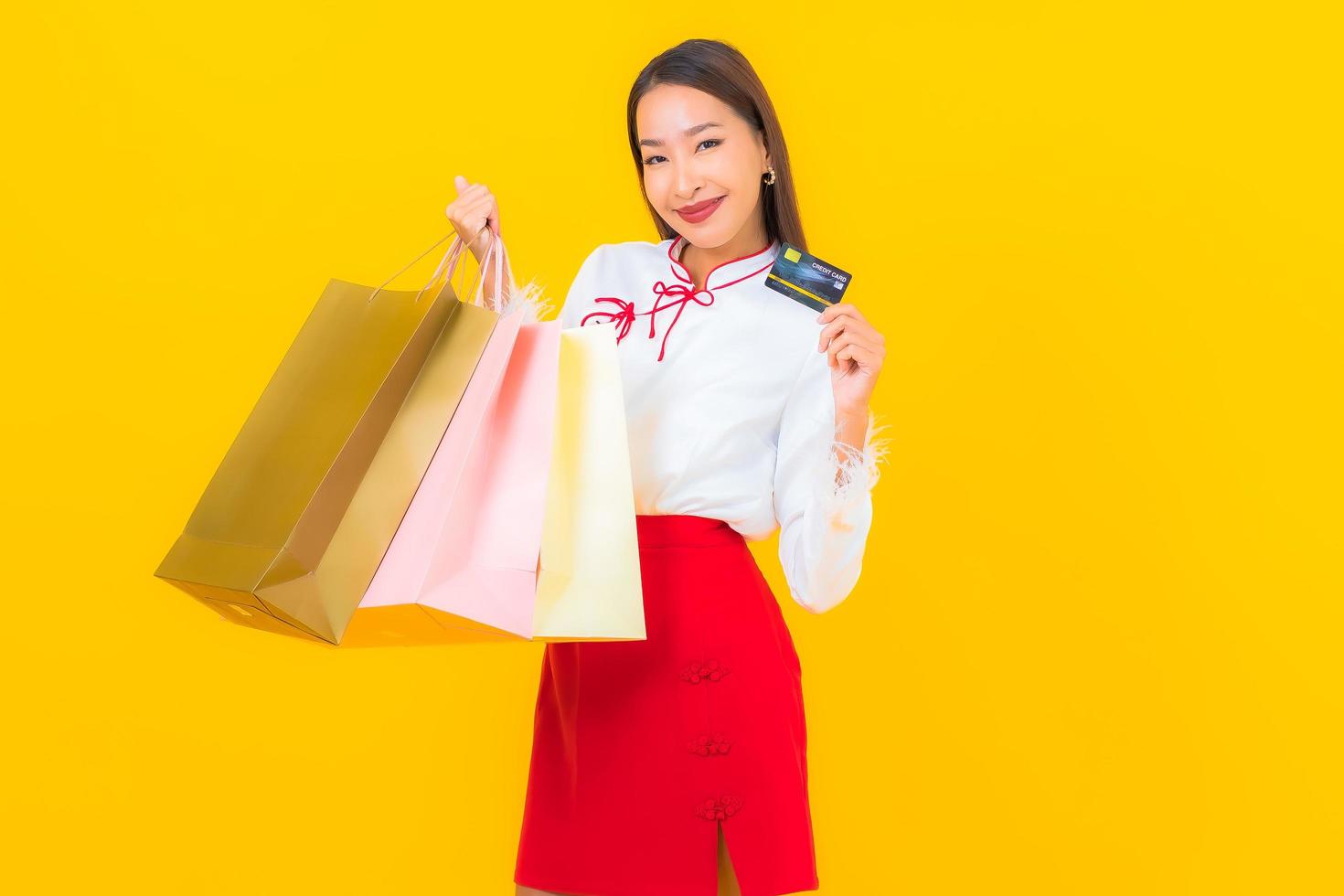 giovane donna asiatica con carta di credito e shopping bag foto