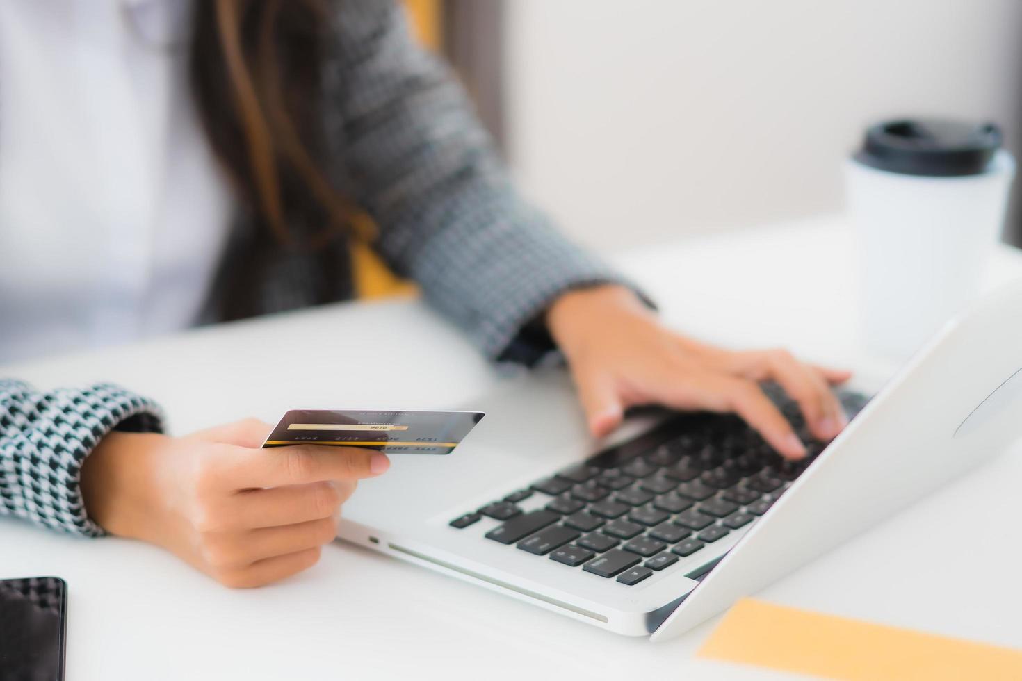 donna utilizzando la carta di credito con il portatile per lo shopping online foto