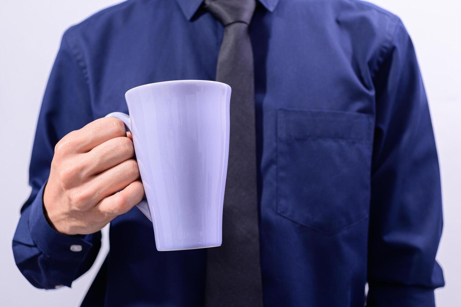 un uomo con in mano una tazza di caffè foto