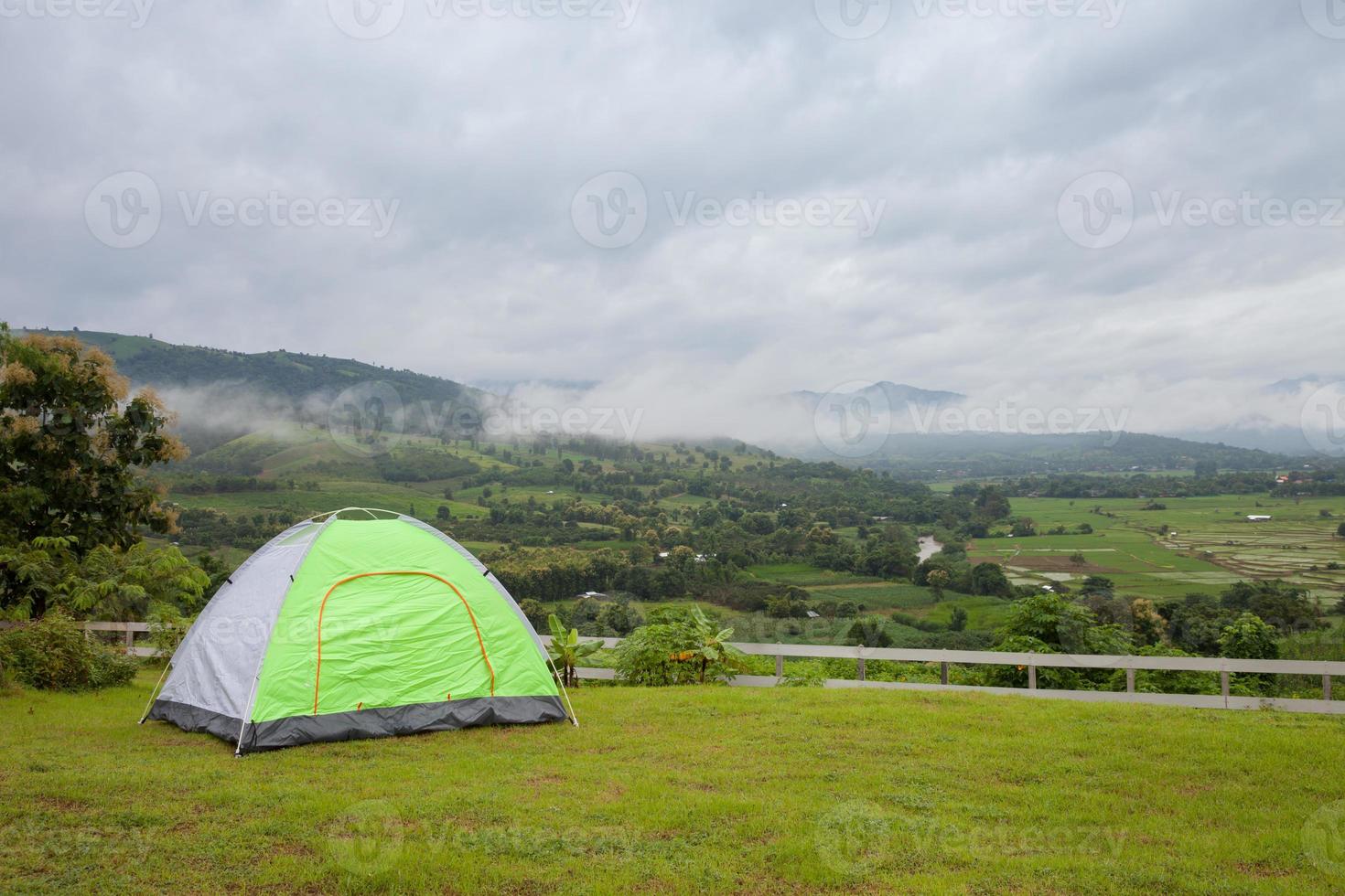 tenda che si affaccia su un nuvoloso paesaggio montano foto