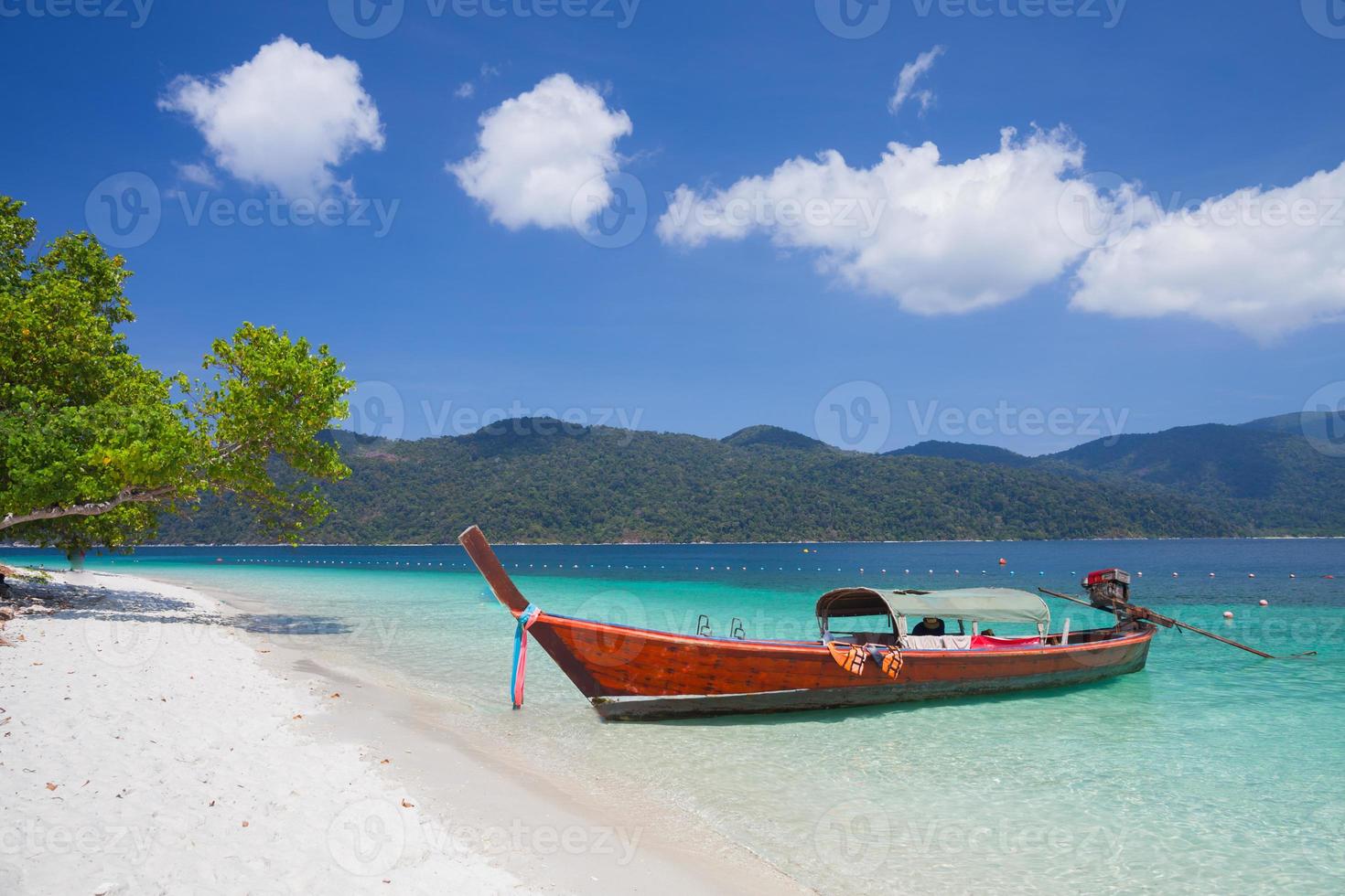 una lunga barca su una spiaggia tropicale foto