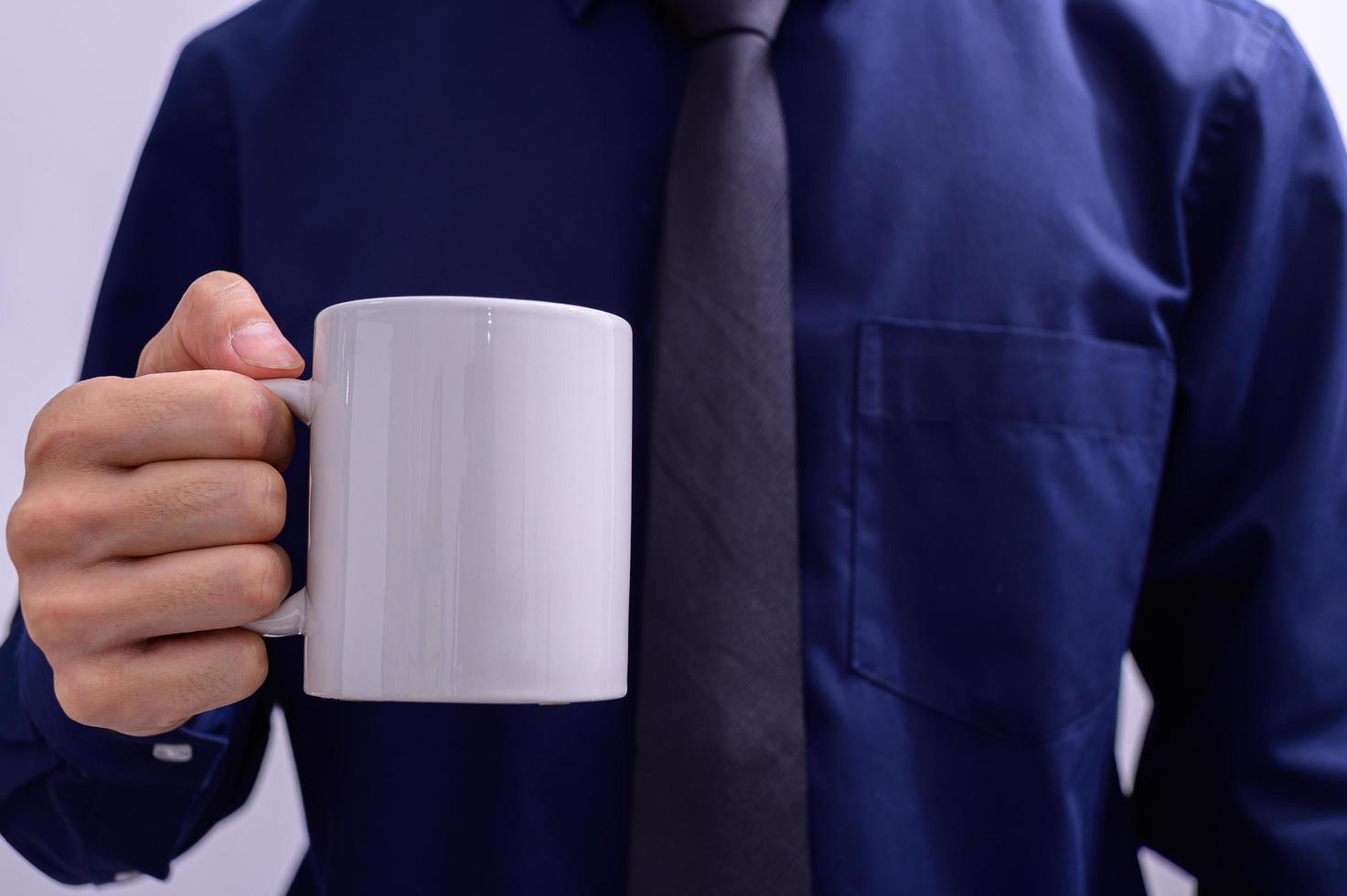 un uomo con in mano una tazza di caffè foto