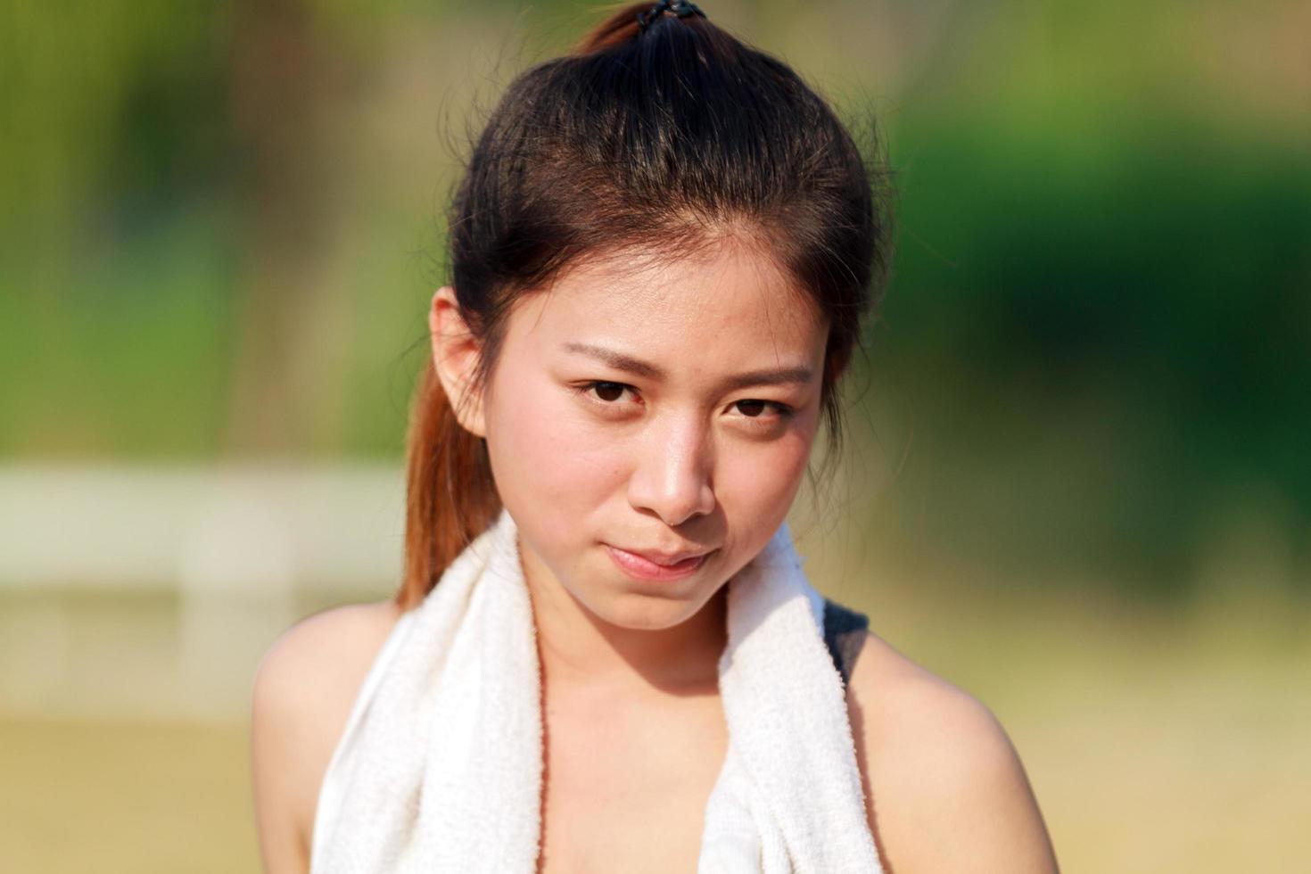 donna asiatica sportiva con un asciugamano sul collo foto
