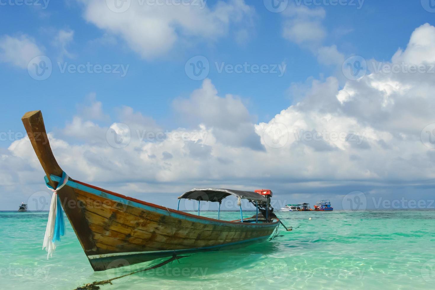 lunga barca galleggiante sulla spiaggia tropicale foto
